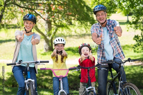 Happy family on their bike with thumbs up at the park