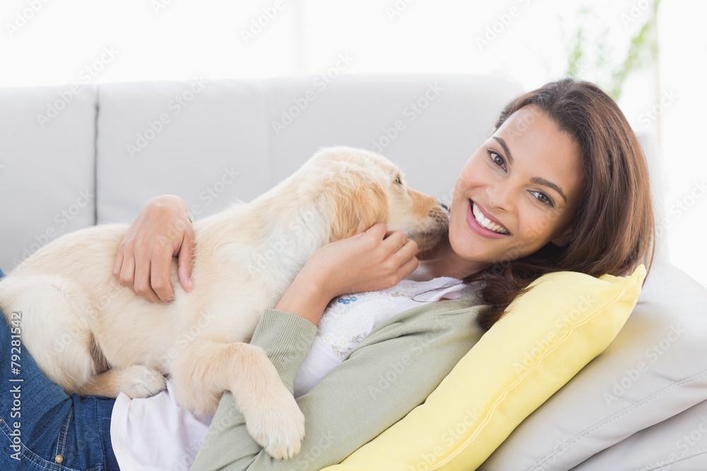Woman playing with puppy on sofa Woman playing with puppy on sofa