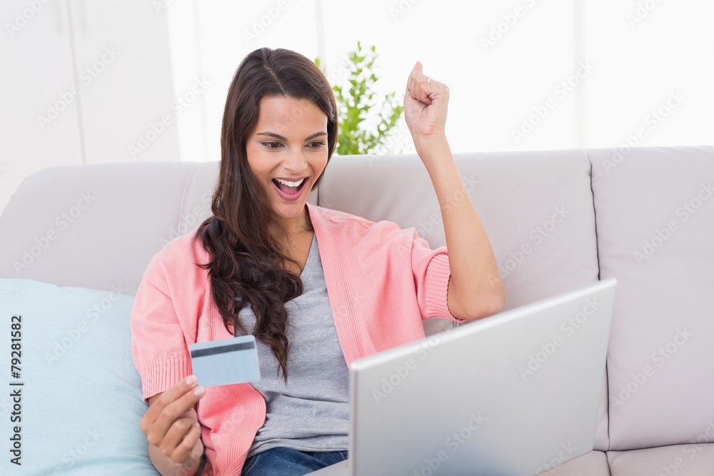 Woman shopping online through laptop using credit card Woman shopping online through laptop using credit card