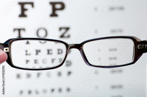 Eye glasses on eyesight test chart background