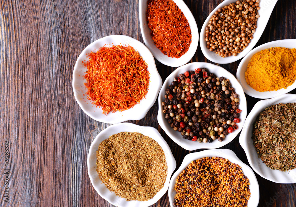 Different kinds of spices in ceramics bowls and spoons Different kinds of spices in ceramics bowls and spoons