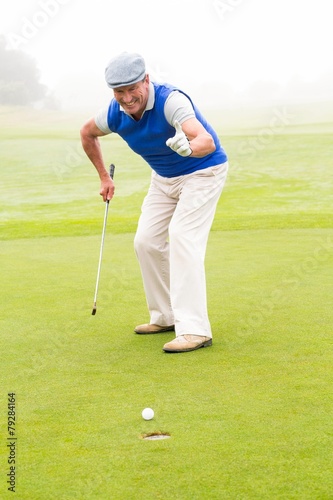 Happy golfer cheering on putting green