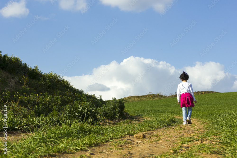 Niña corriendo y caminando feliz por el camino en el campo Niña corriendo y caminando feliz por el camino en el campo