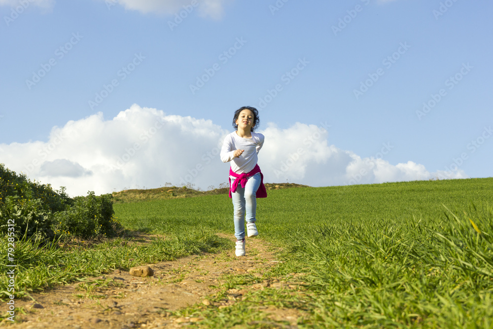 Niña corriendo y caminando feliz por el camino en el campo