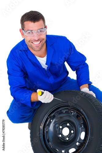 Portrait of happy mechanic working on tire © WavebreakmediaMicro
