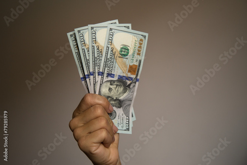 Hand showing notes of one hundred US dollars.