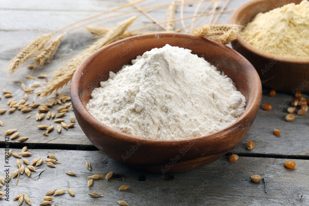 Flour in bowls with grains on wooden background Flour in bowls with grains on wooden background
