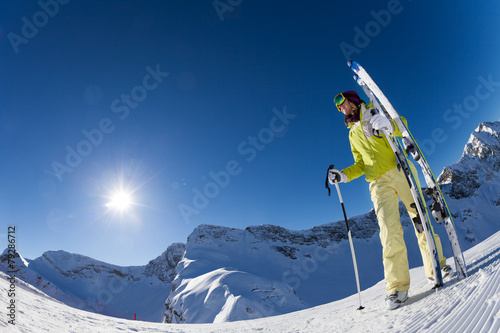 Fisheye view of woman holding ski with poles