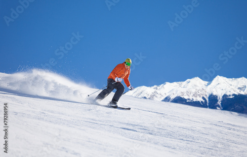 Sportsman in ski mask sliding fast while skiing