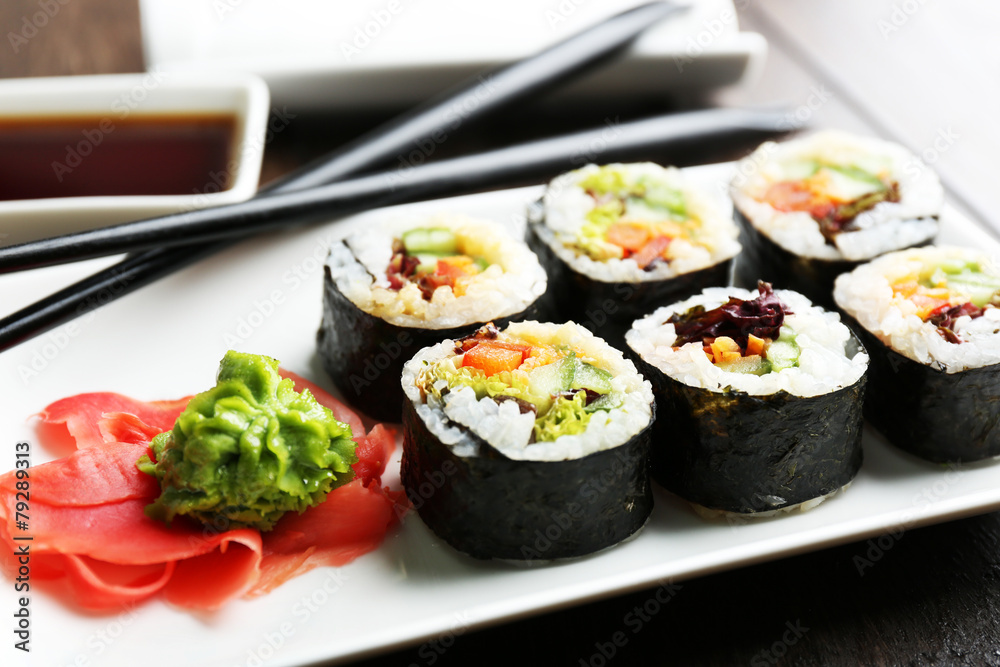 Vegetarian sushi rolls on plate, on wooden background Vegetarian sushi rolls on plate, on wooden background