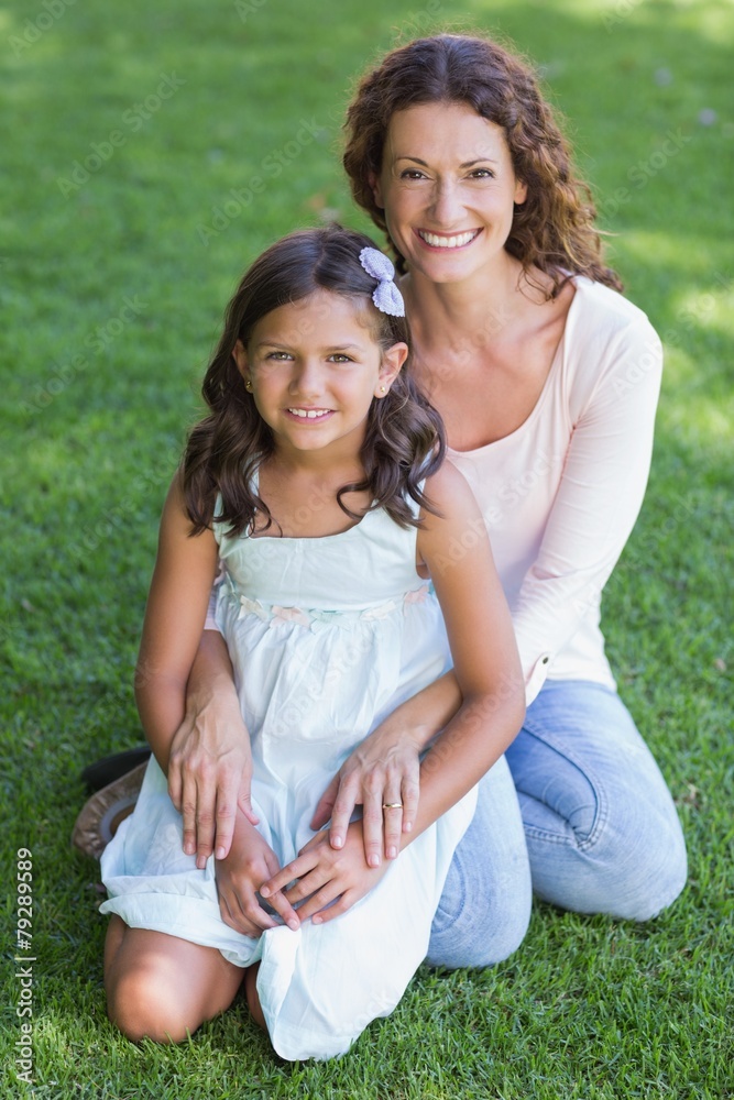Happy mother and daughter sitting on the grass Happy mother and daughter sitting on the grass