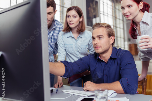 mann zeigt seinen kollegen etwas am computer photo