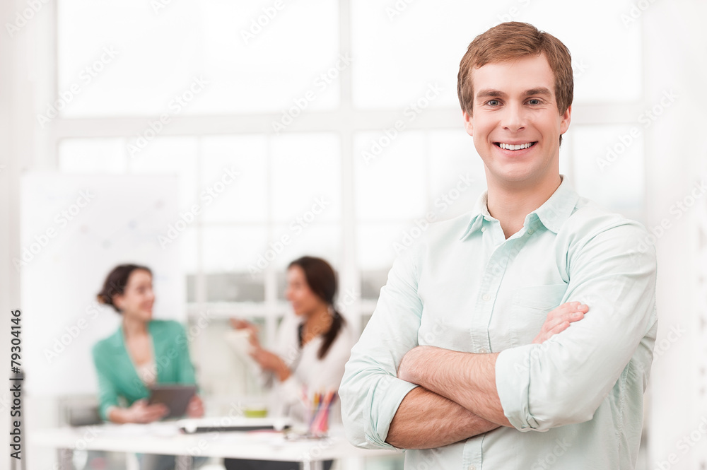 Young smiling businessman looking at camera