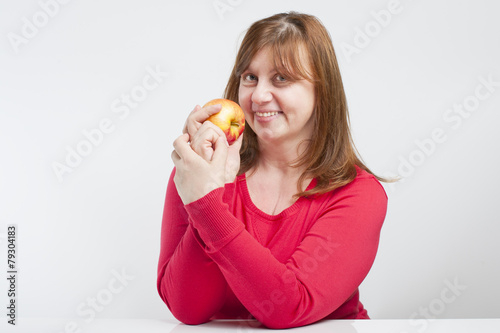 Middle-aged woman holding a ripe apple..
