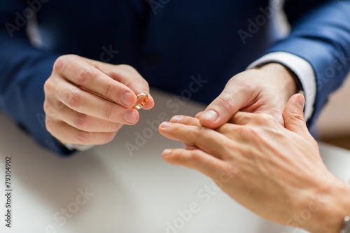 close up of male gay couple hands and wedding ring