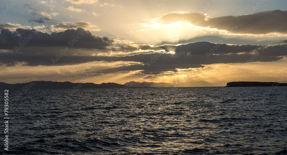 Obraz premium sunset behind the clouds over sea