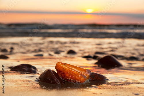 Murais de parede Amber stone on the beach. Precious gem, treasure. Baltic Sea
