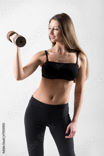 Smiling young girl doing weightlifting