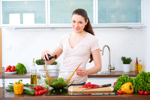 Young woman in the kitchen prepare salad IX