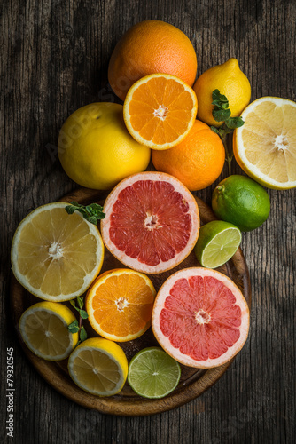 Fototapeta Naklejka Na Ścianę i Meble -  Halves of citrus fruits on wooden background. Orange, grapefruit