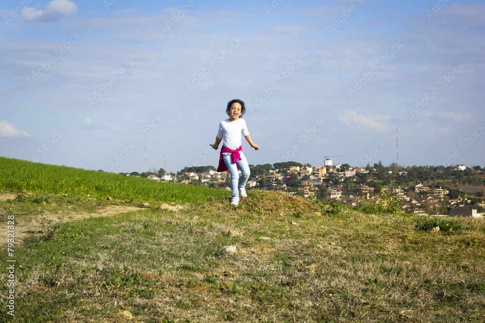 Fototapeta premium Niña saltando en el campo