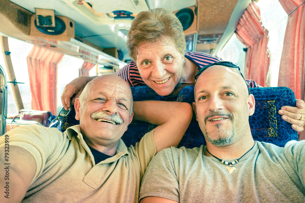 Senior happy couple with son taking a selfie during a bus trip Senior happy couple with son taking a selfie during a bus trip