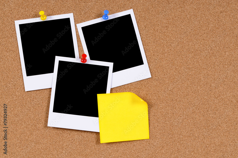 Fototapeta premium Several three polaroid style blank photo frame prints with sticky note pinned to cork notice board background