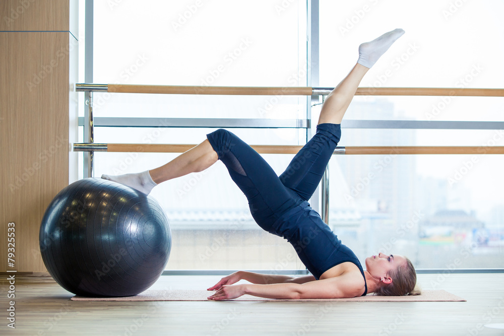 Young girl working out at the gym with a ball - obrazy, fototapety, plakaty 