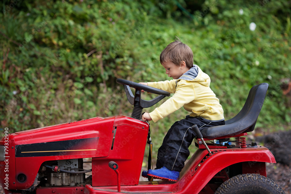Adorable little boy, pretending to ride a lawn mower Adorable little boy, pretending to ride a lawn mower