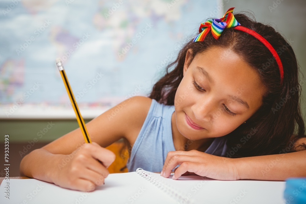 Little girl writing book in classroom Stock Photo