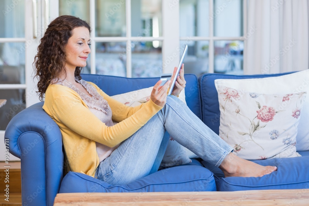 Pretty brunette relaxing on the couch with tablet Pretty brunette relaxing on the couch with tablet