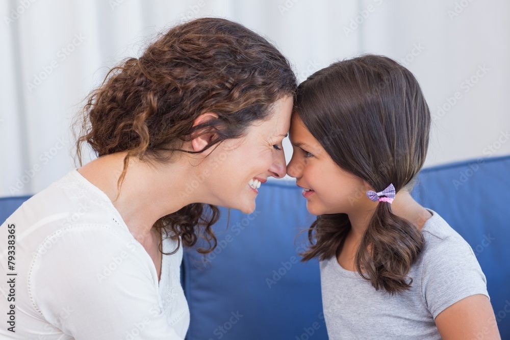 Happy mother and daughter smiling at each other Happy mother and daughter smiling at each other