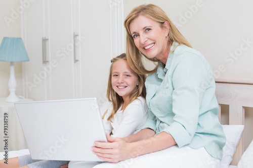 Happy mother and daughter using laptop © WavebreakmediaMicro