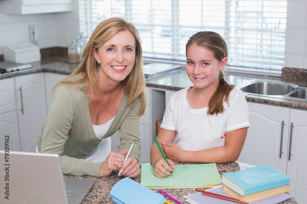 Happy mother helping daughter doing homework Happy mother helping daughter doing homework