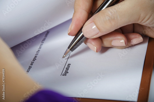 Young woman signing a document