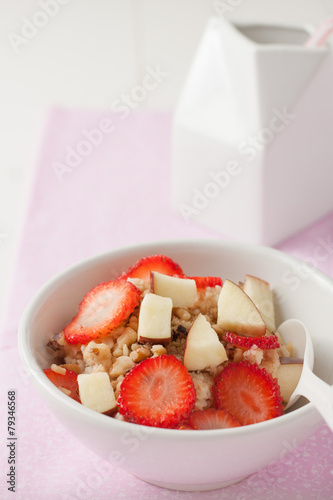 a bowl of oatmeal with fruit and nuts