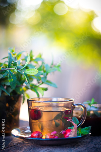 Autumn tea in black glass cup on old grey rustic wooden table