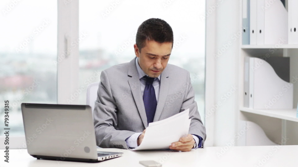 smiling businessman with laptop and papers smiling businessman with laptop and papers