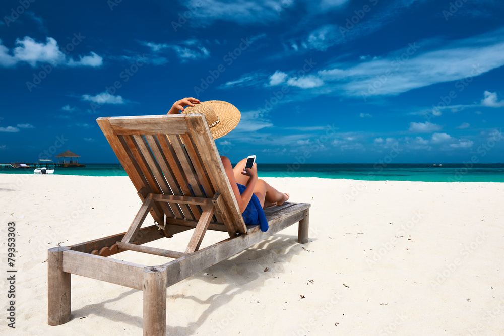 Young woman with mobile phone at the beach