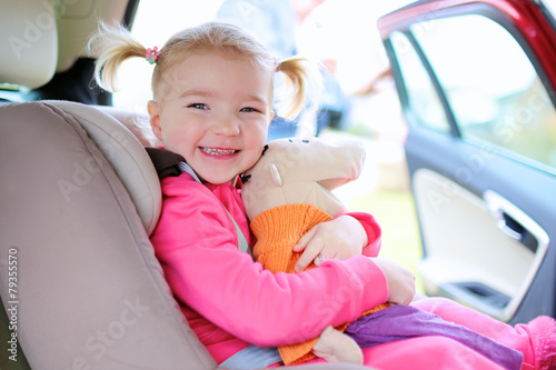 Preschooler girl sitting in child seat in the car © cromary