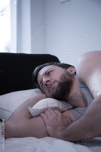 Awake man lying in bed