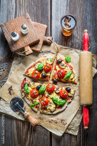 Closeup of baked pizza with olives and tomatoes