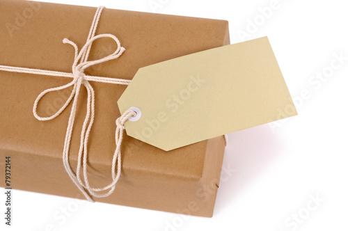 Brown paper package with white string and tag isolated on white background photo