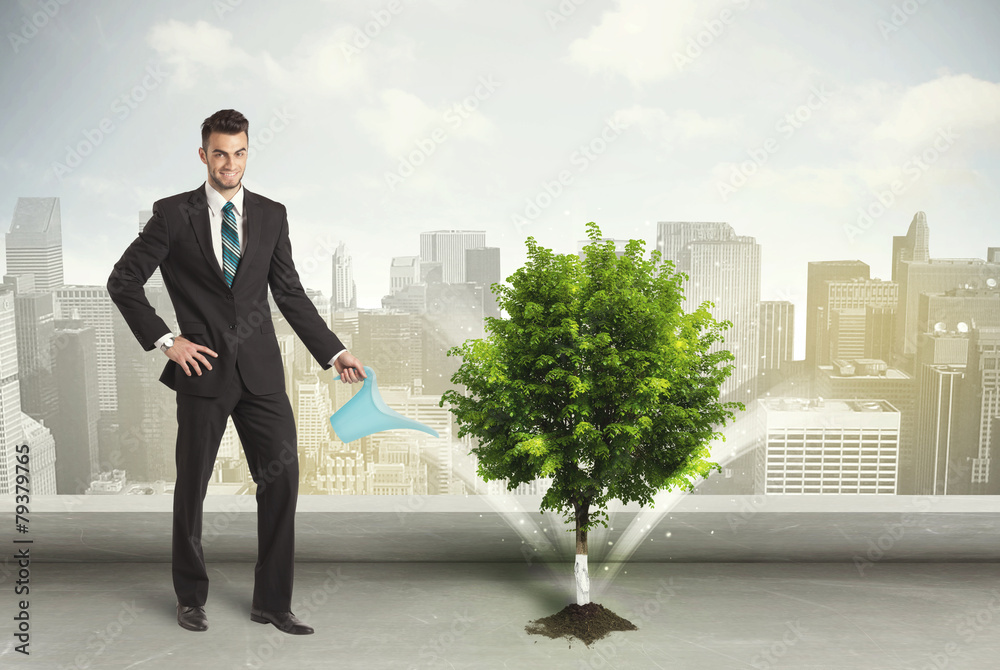 Businessman watering green tree on city background Businessman watering green tree on city background