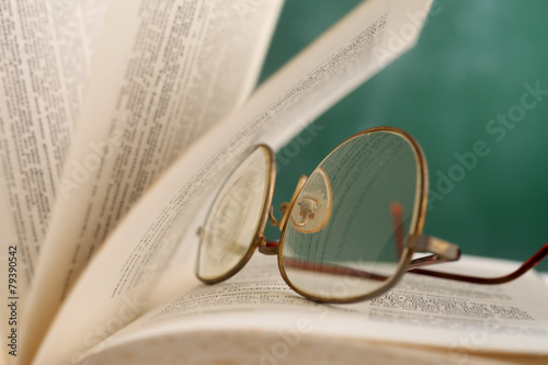 open page at glasses resting on the book photo