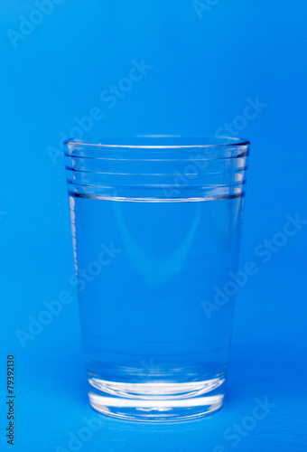 Glass of water over a blue background.