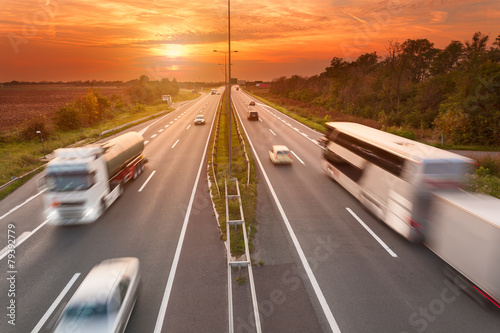 Truck and bus on the motorway at sunset