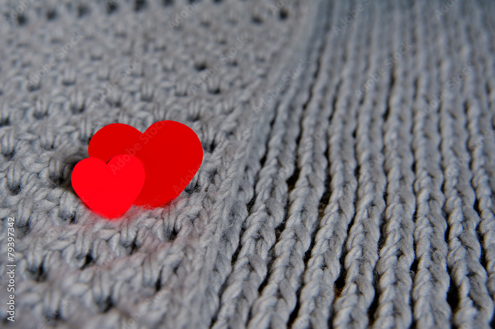 Fototapeta premium Handmade grey knitting wool texture background with red hearts