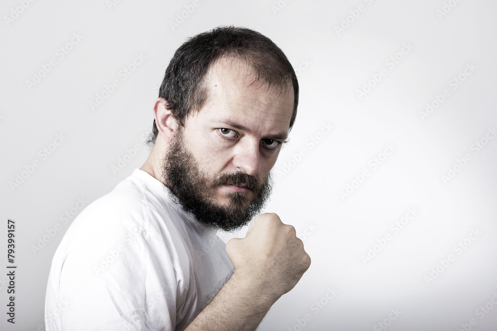 Young man with beard, showing fist, ready to fight Young man with beard, showing fist, ready to fight