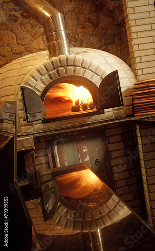 A lit stone baked pizza oven